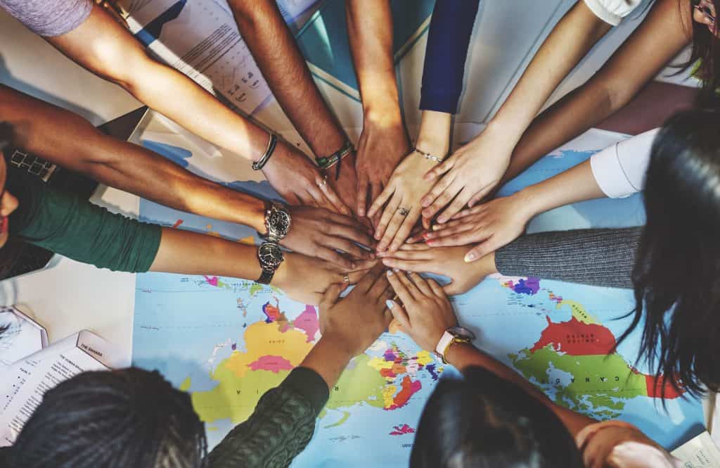 Hands United Over a World Map